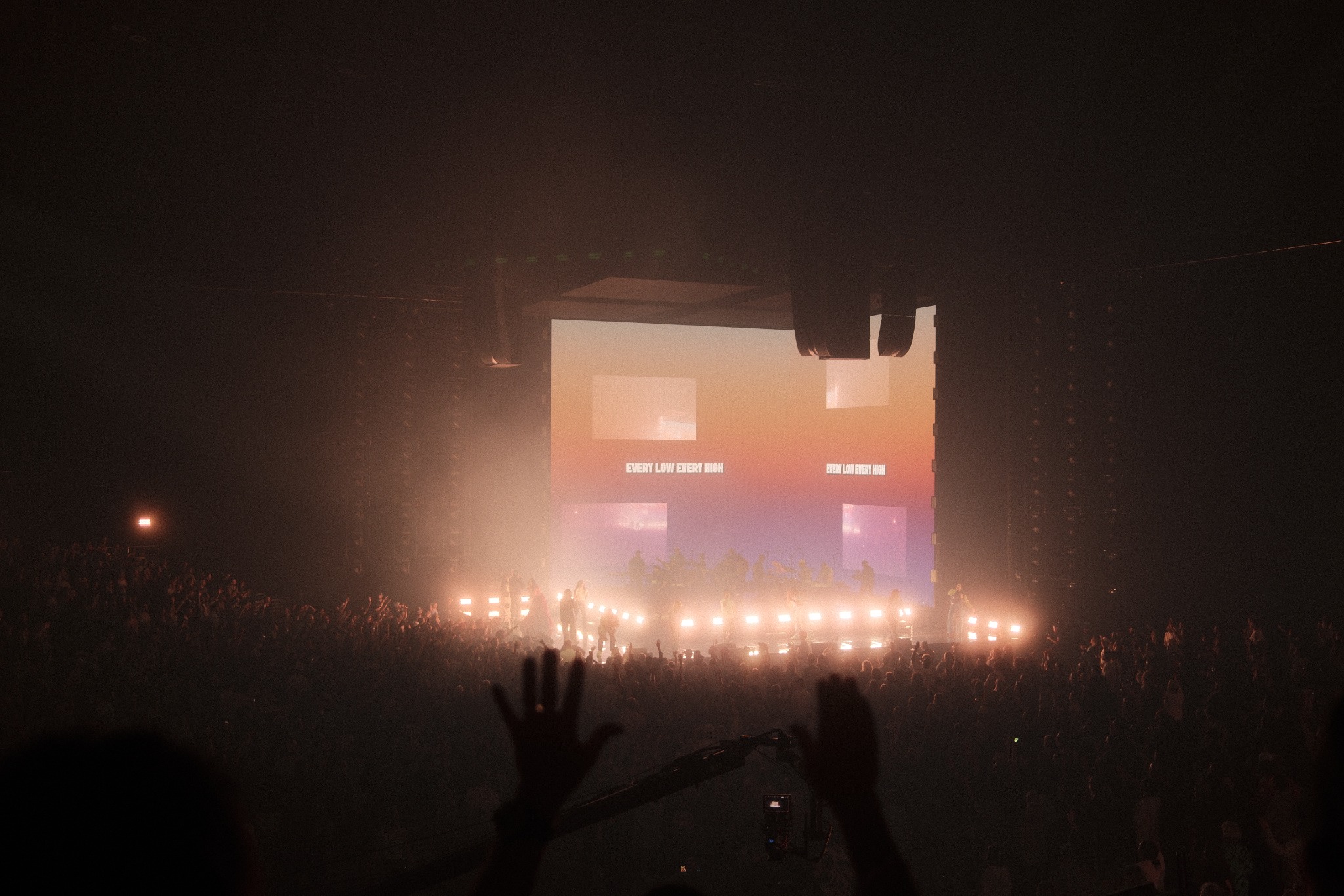 Concert crowd with hands raised toward the stage